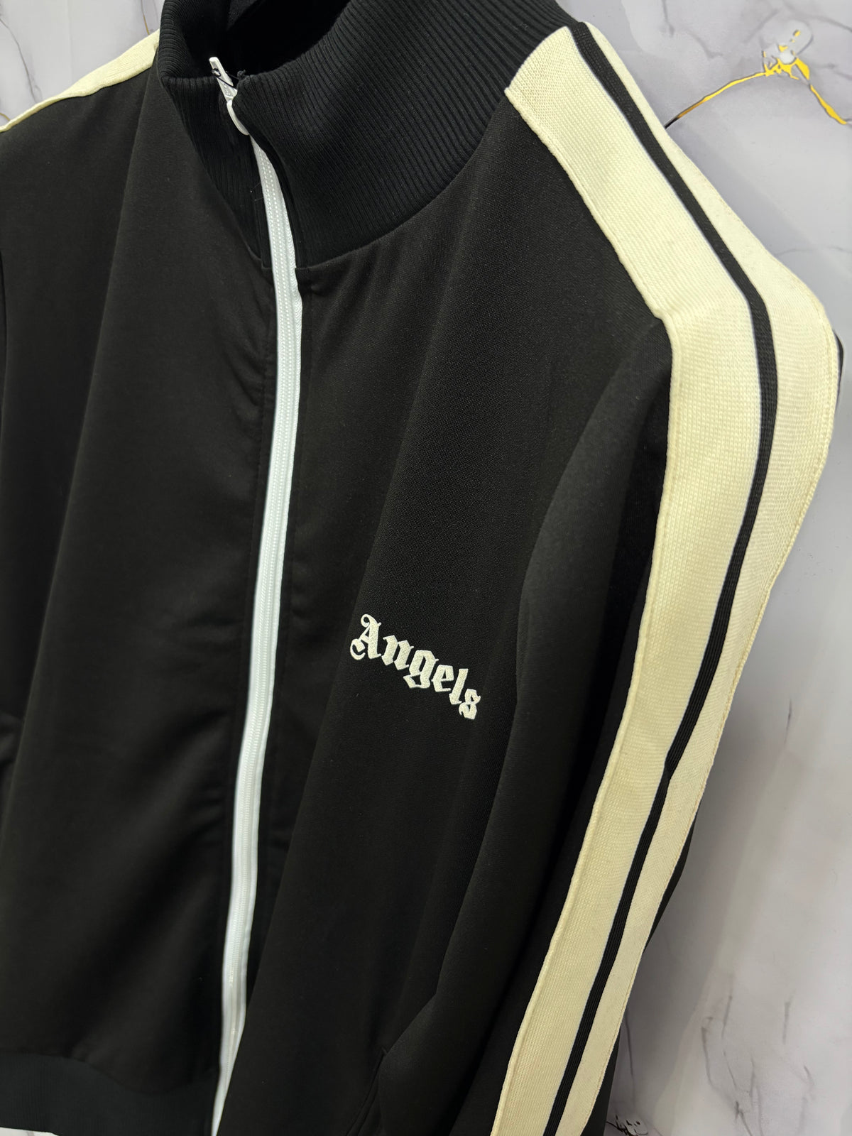 TUTA PALM CLASSICA stylish black jacket with white zipper and contrasting stripes, featuring 'Angels' logo detail.
