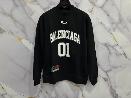 FELPA BALENCIAGA 01 black sweatshirt with large white lettering on a marble background.