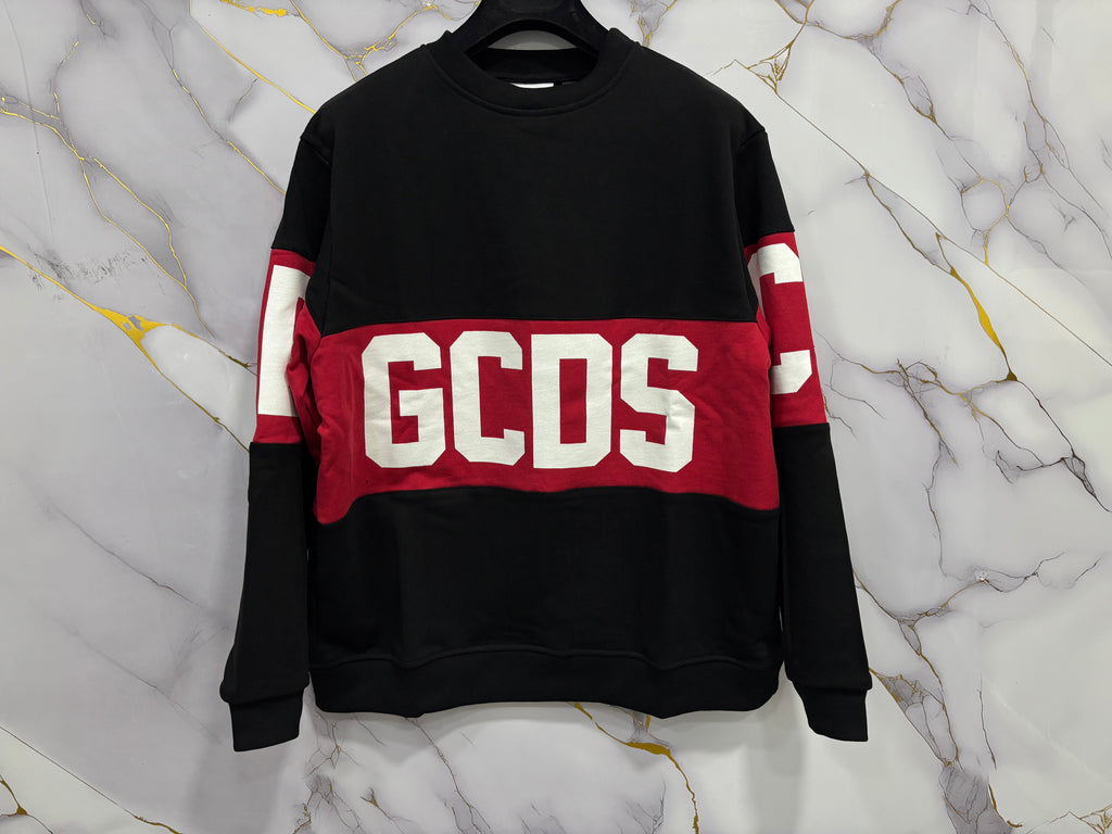FELPA GCDS GIROCOLLO displayed on a marble background, showcasing its stylish design and bold branding.