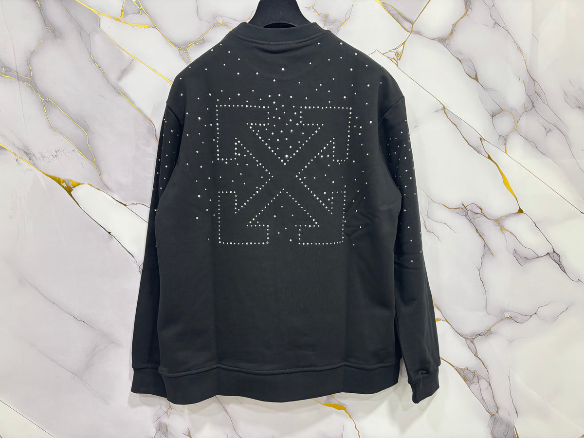 FELPA OFF-WHITE BRILLANTINATA with studded design on back against a marble background.