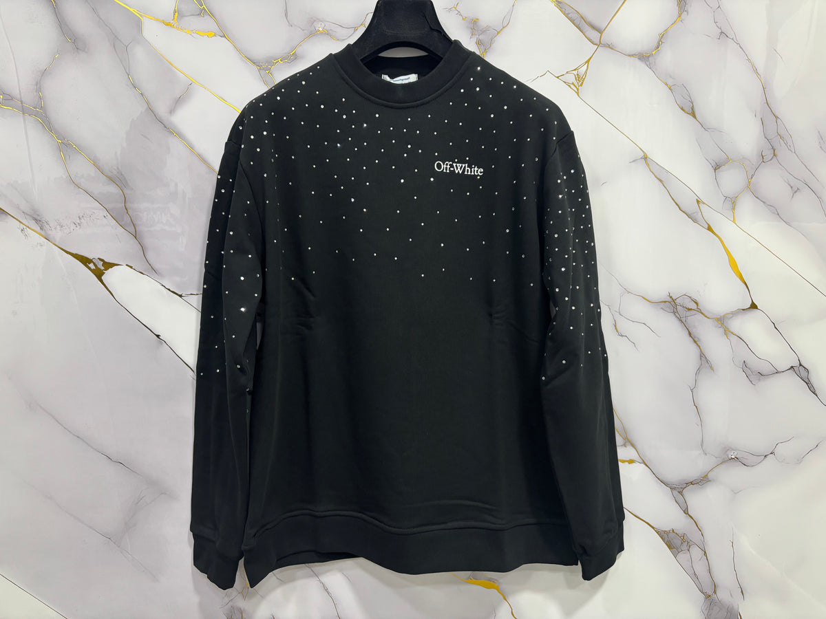 FELPA OFF-WHITE BRILLANTINATA black sweatshirt adorned with sparkling studs against a marble background.