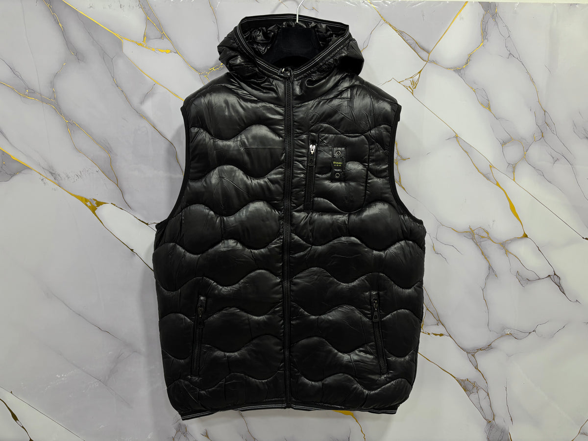Stylish SMANICATO BALUER black padded vest on a marble background, perfect for layering in any season.